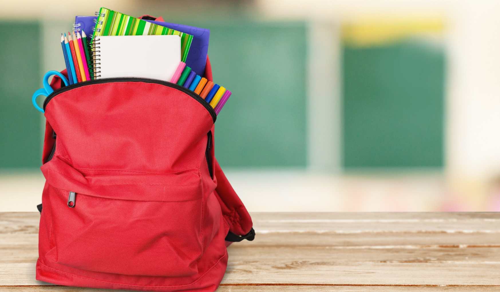 bunch of school supplies in red backpack