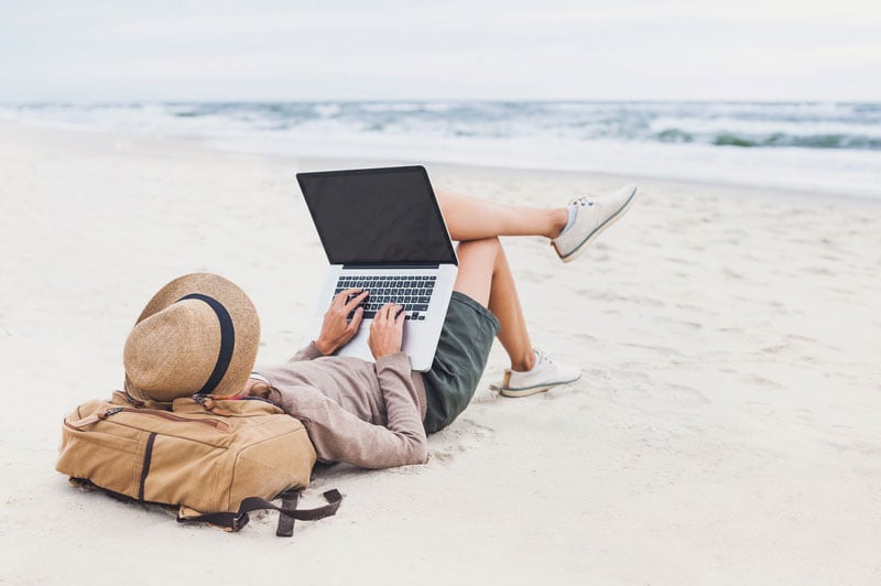 woman on beach with laptop
