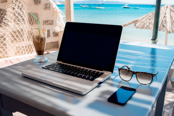 laptop on table facing beach