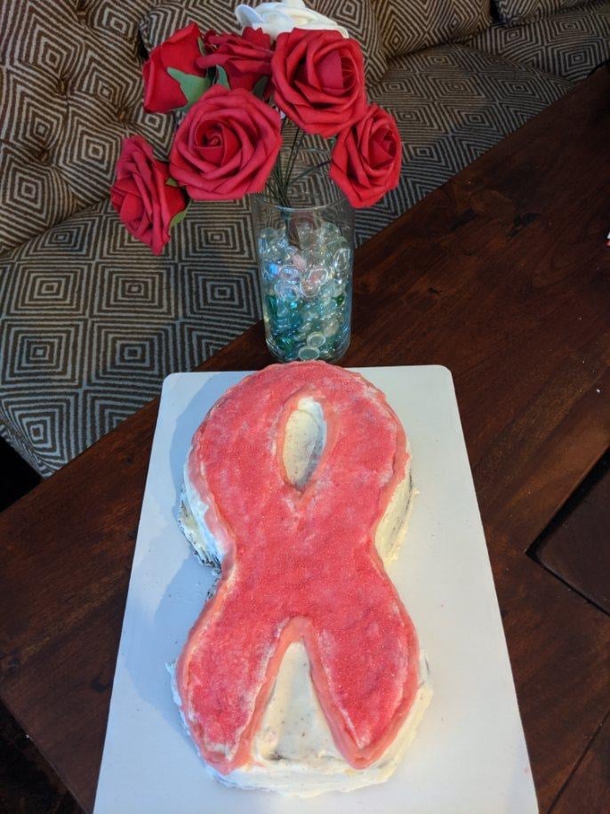 a cake shaped like a pink ribbon