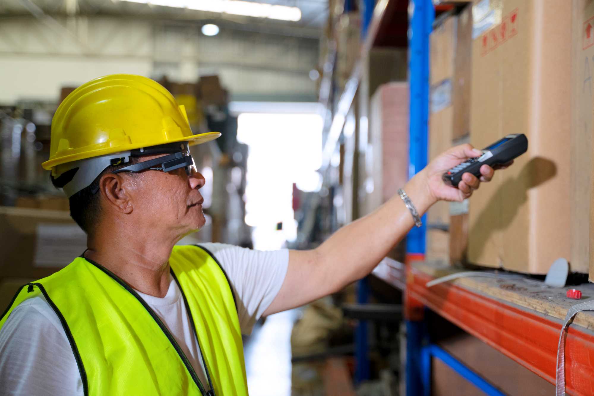 Worker with goggles holding a barcode scanner.