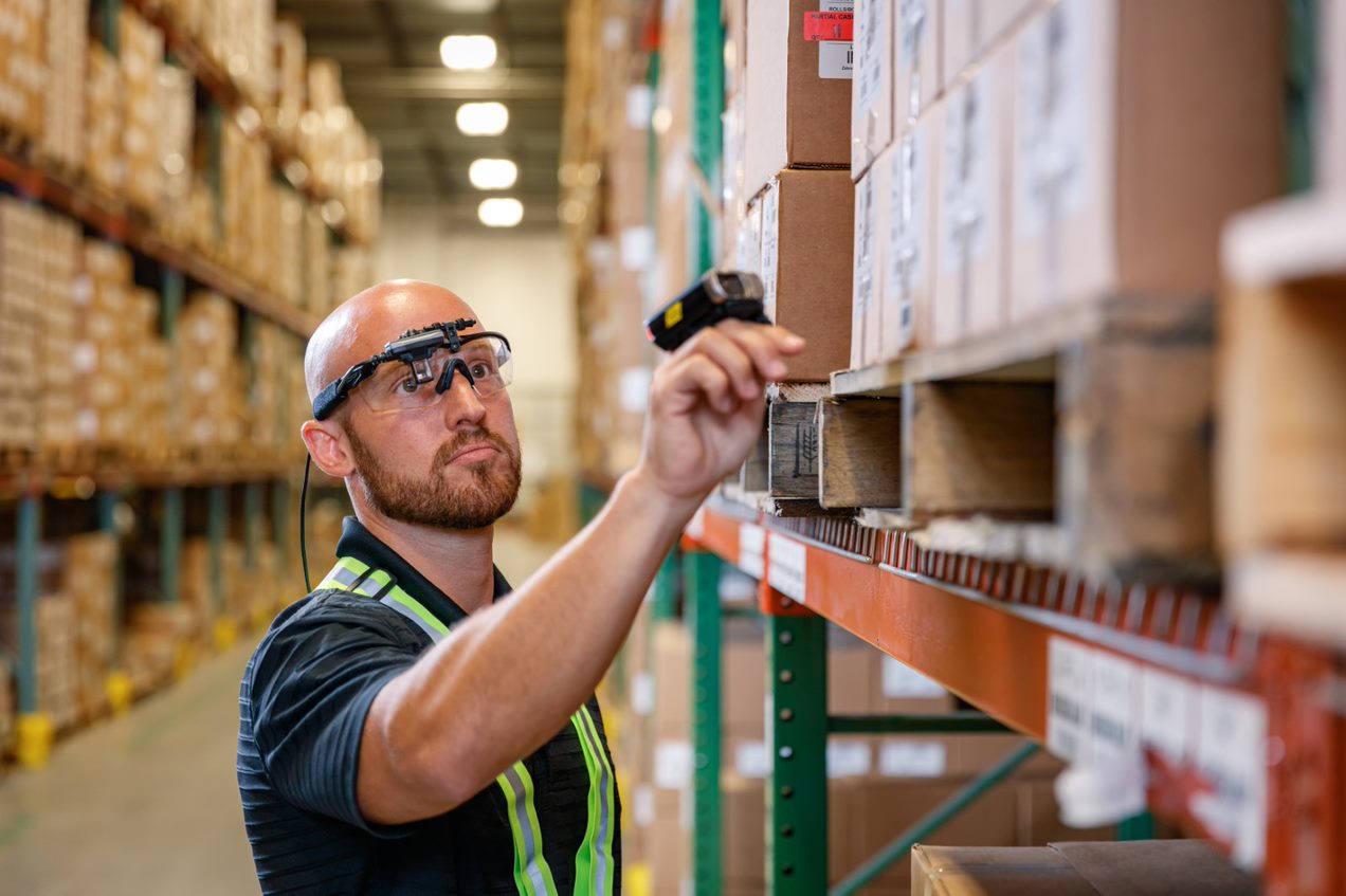 Worker with goggles holding a barcode scanner.