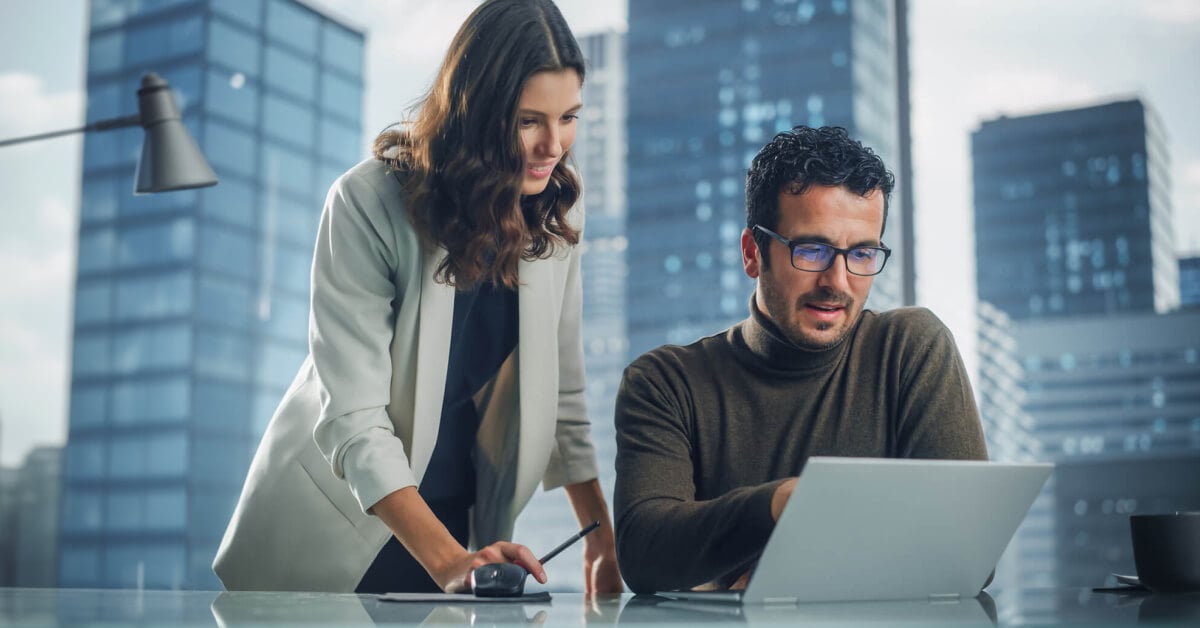 Woman and man looking at data on a laptop