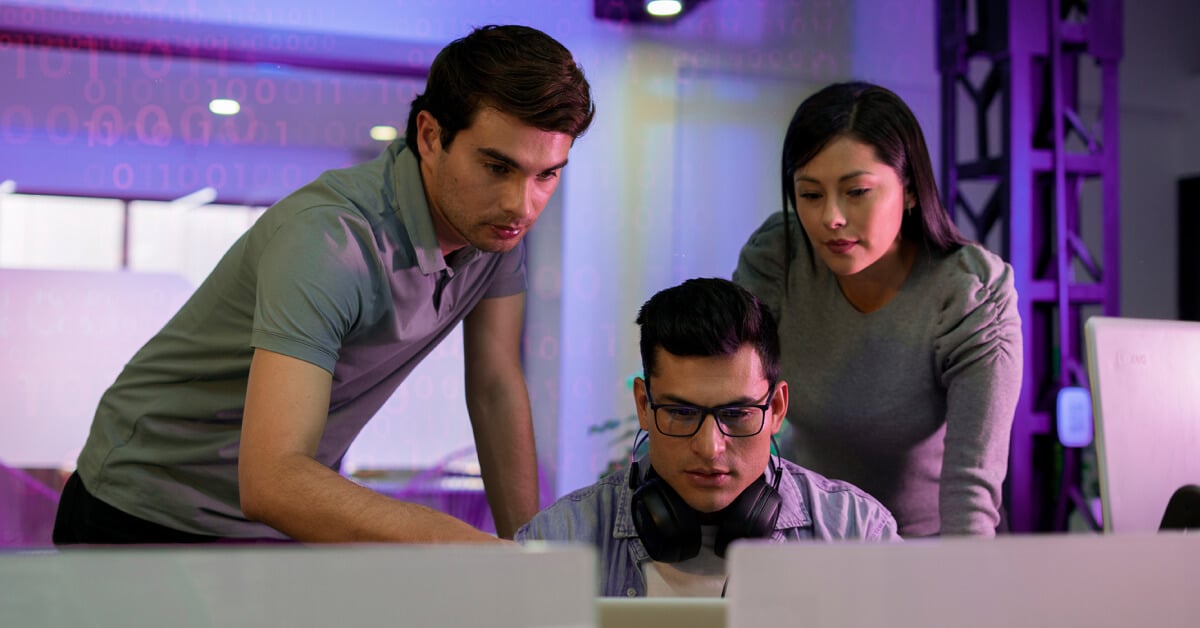 office workers looking at a laptop display