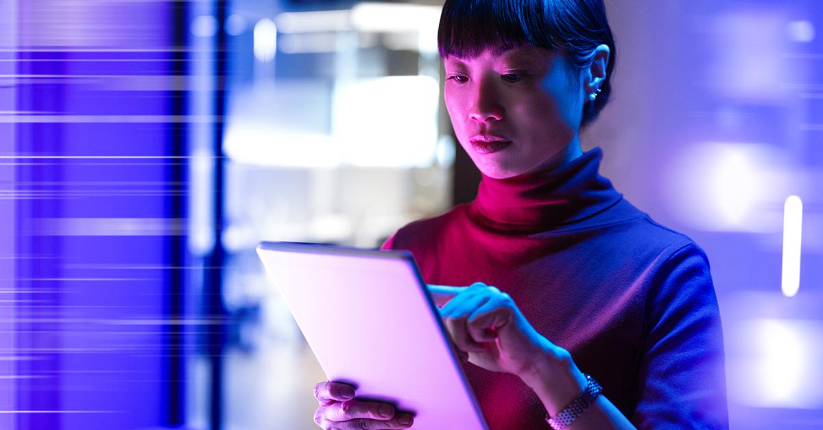 Woman interacting with a tablet device held in her hands.