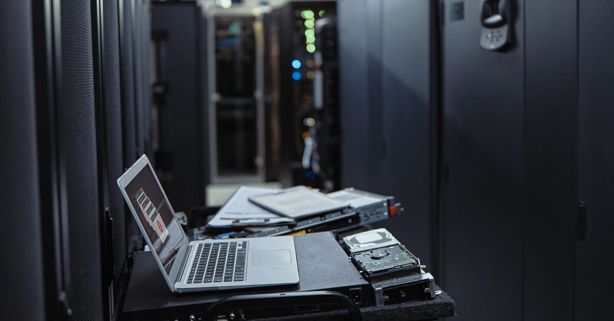 Laptop on a desk inside a server room.