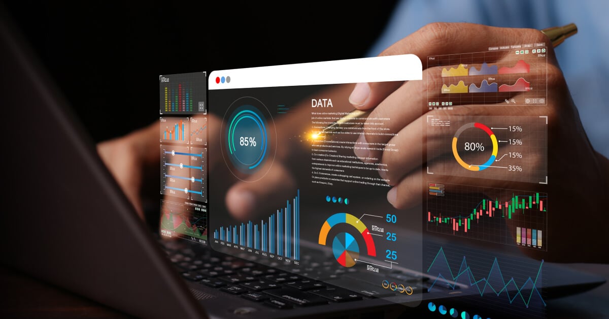 Holographic image of an analytics dashboard floating above a laptop keyboard that a person is interacting with.
