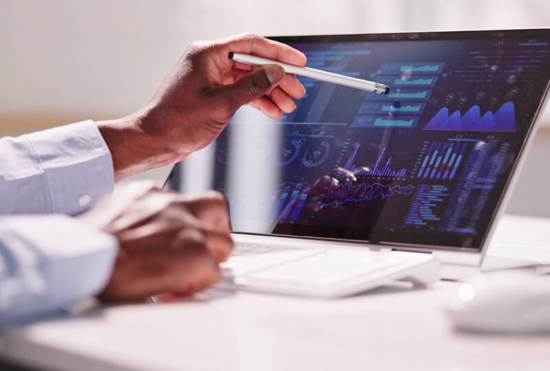 A person holding a stylus and interacting with a touchscreen computer.