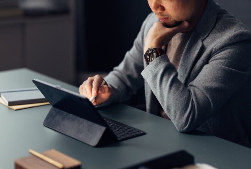 A person interacting with a tablet computer on a table.