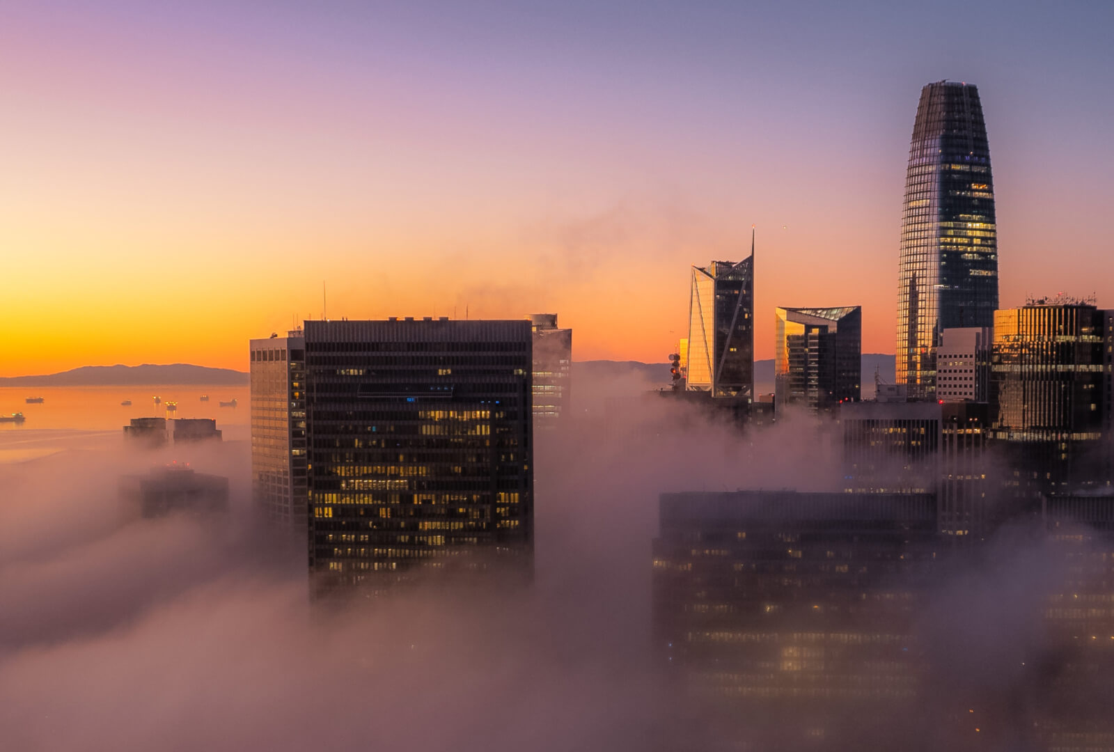 A cloudy San Francisco skyline at sunset with the Salesforce building toward the right of the frame.