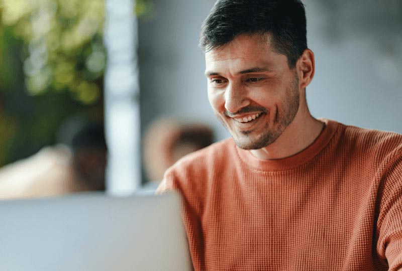 a man attending a video call on a laptop in a public location