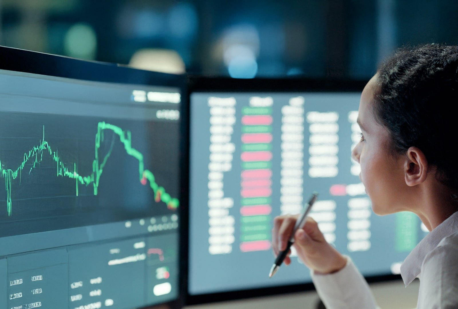 woman looking at data on a dual monitor setup