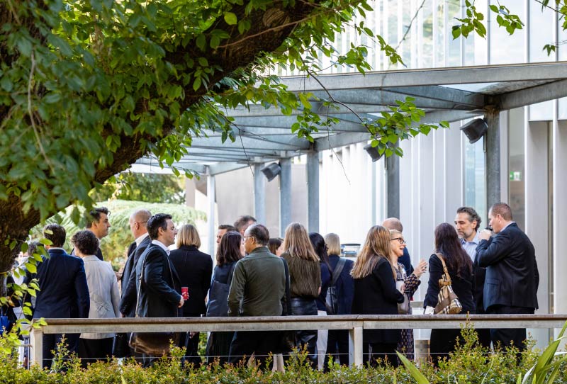 image of a group of people drinking and chatting outside a building