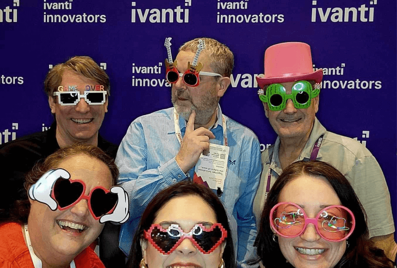 A group of 6 people wearing funny looking sunglasses posing for a photo.