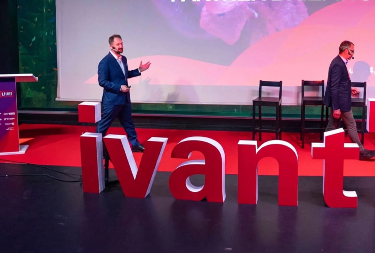 a presenter on a stage behind an ivanti logo