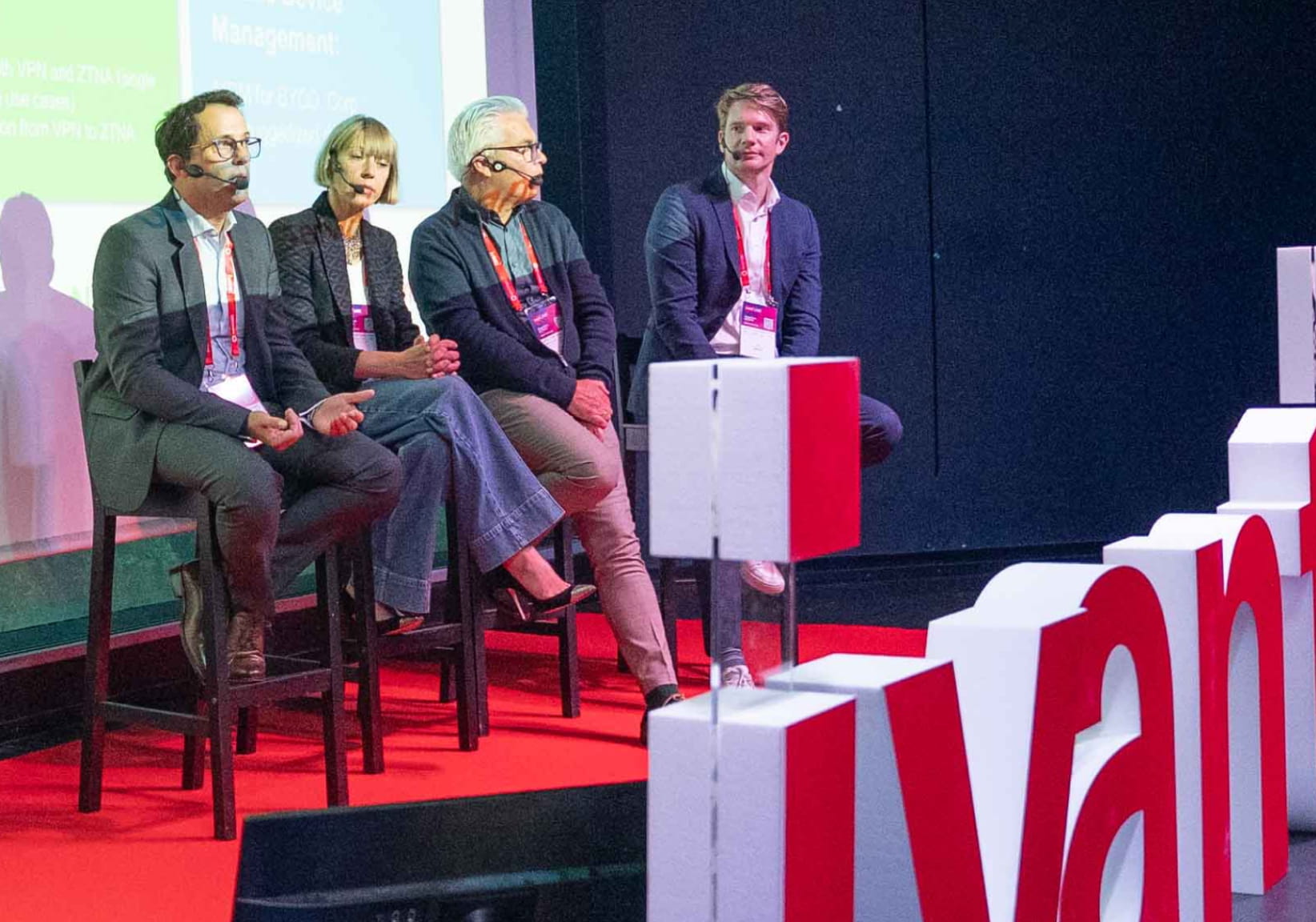 panel speakers on a stage behind an ivanti logo
