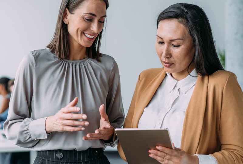 two women looking at a tablet