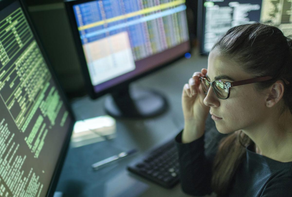 woman looking at data on computers