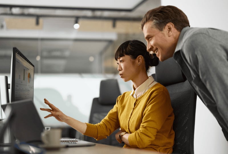 co-workers discussing data one a monitor