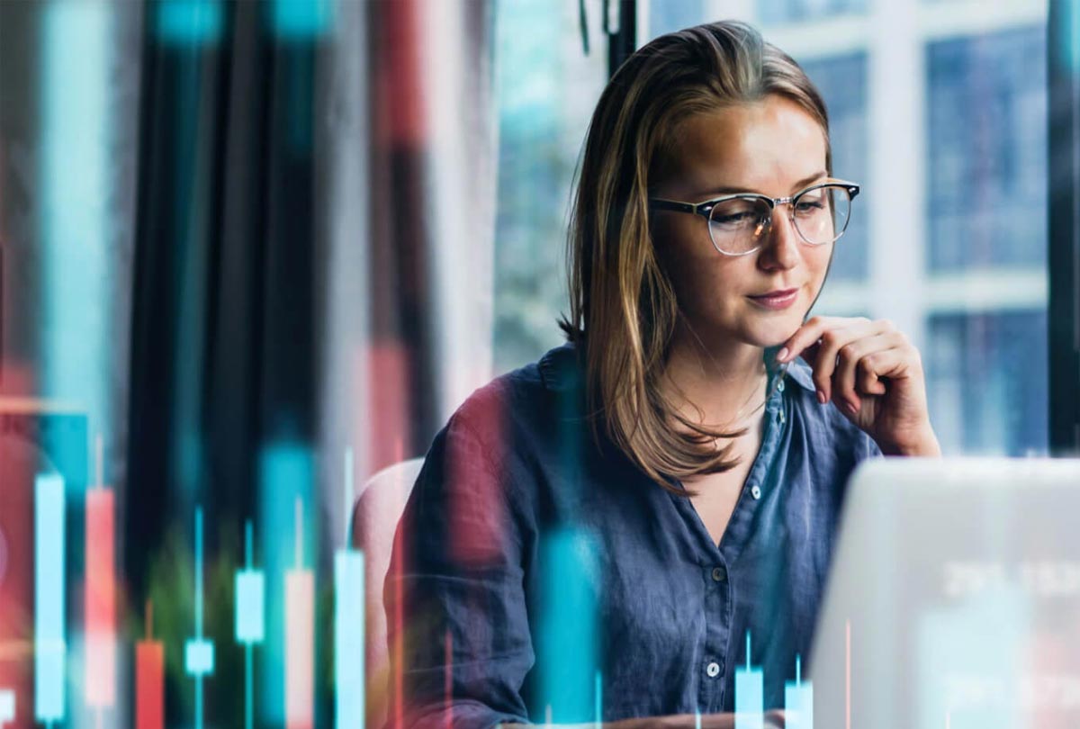 Woman wearing glasses interacting with a laptop.