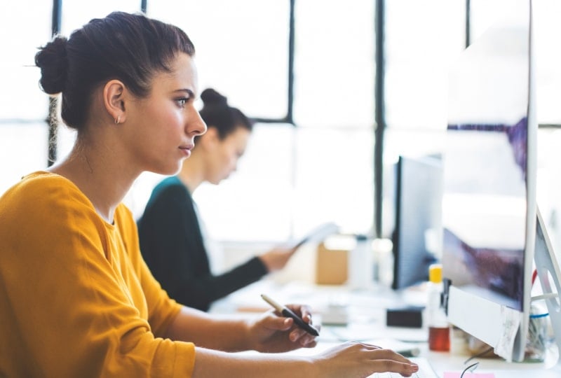 Woman looking at a desktop computer screen.