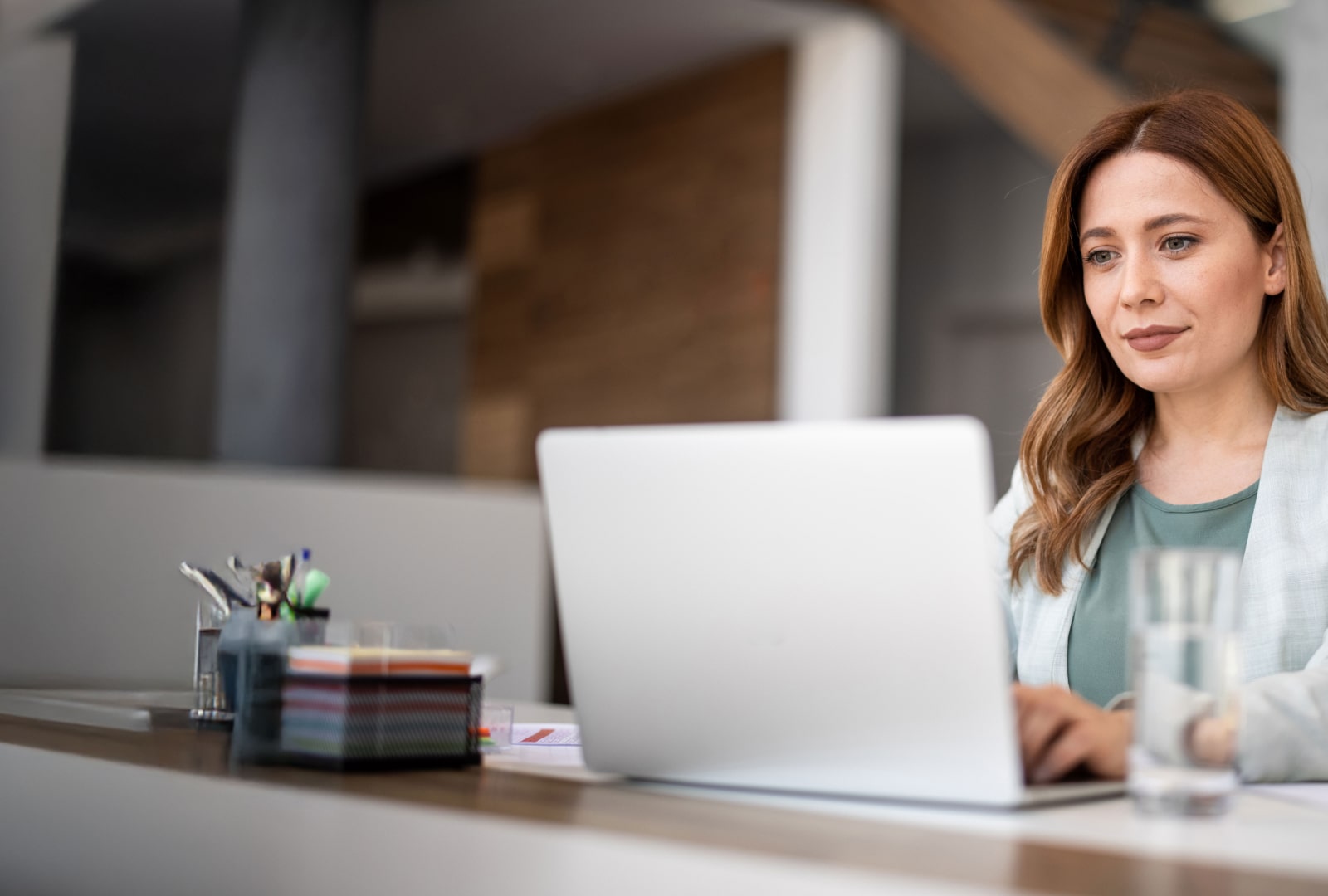 Smiling woman looking at a laptop on her desk.