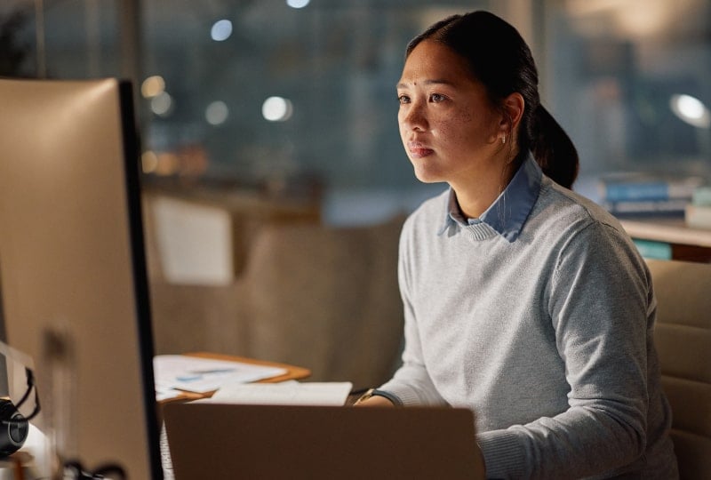 Woman looking at a desktop computer monitor.