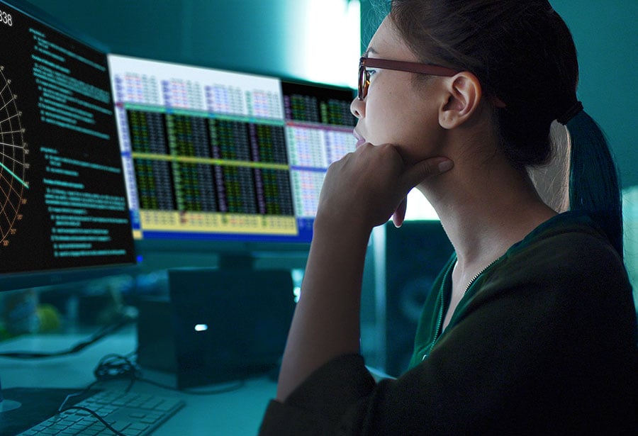 a woman looking at computer screens