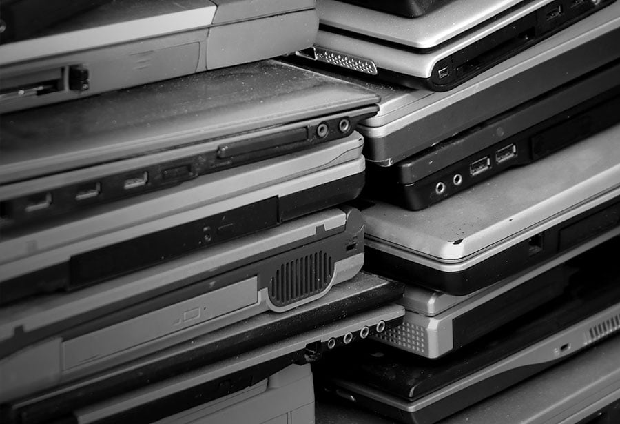 old dusty laptops stacked on each other