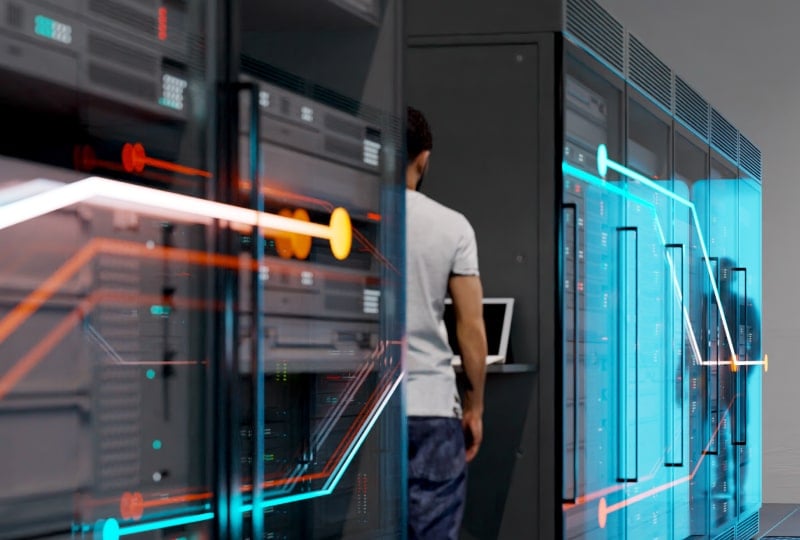 View into a server room with a man standing at an access terminal.