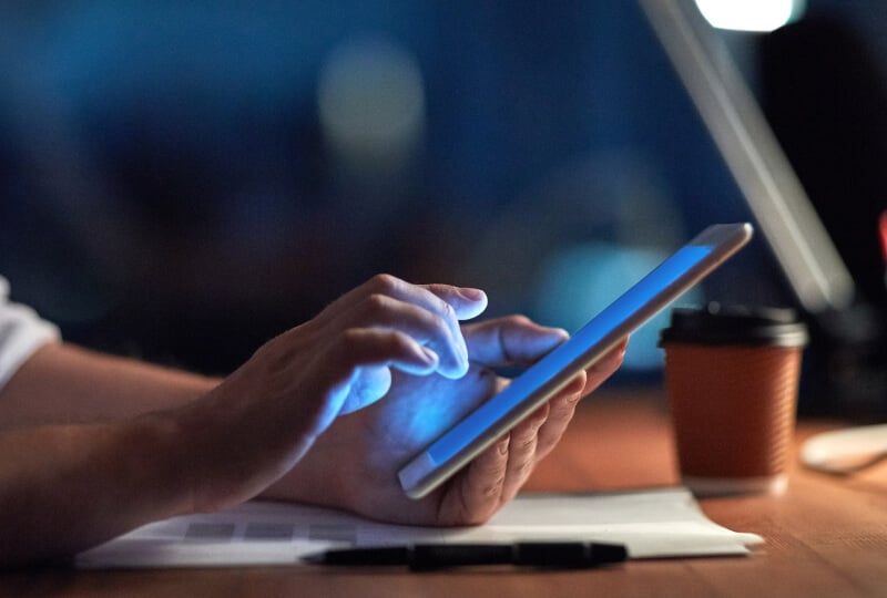 man typing into a tablet device