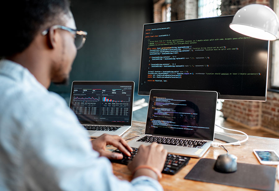 man on computers using code