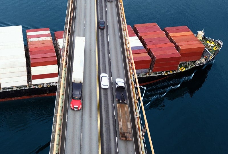 一位穿衬衫的男子与一位穿警示背心的男子在仓库讨论