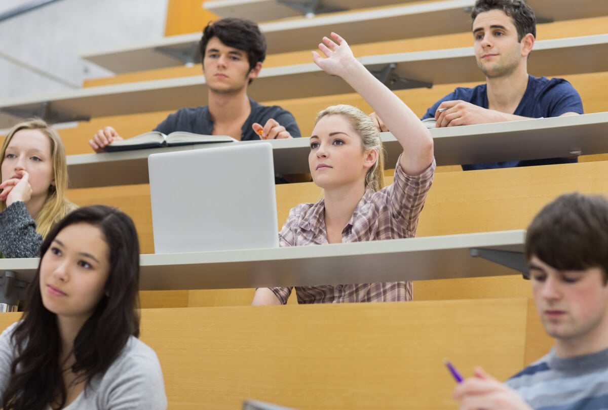 一位年轻女学生在礼堂举手提问