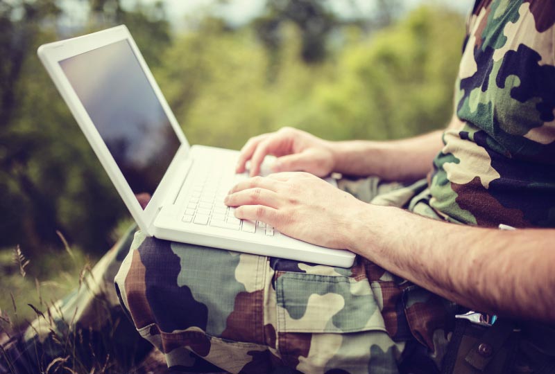 Un soldat interagissant avec un ordinateur portable.