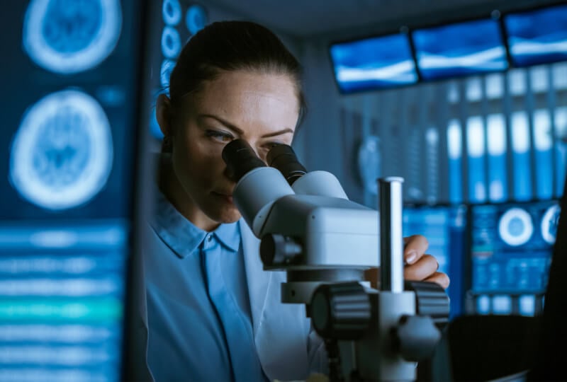 女性在实验室用显微镜观察