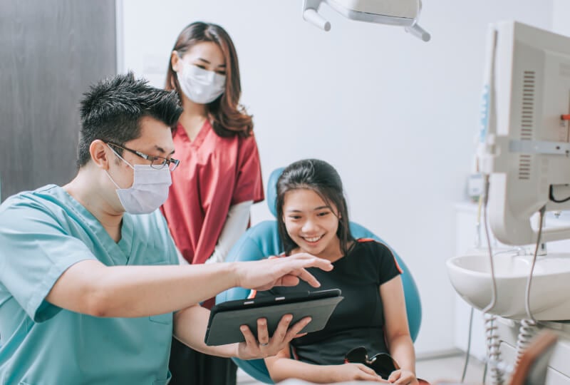 医生使用平板设备向女患者展示内容