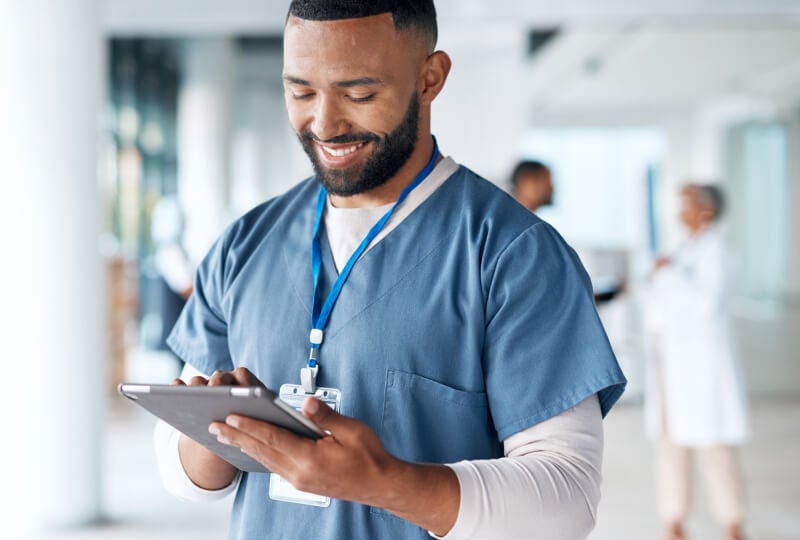 男护士在医院走廊使用平板电脑