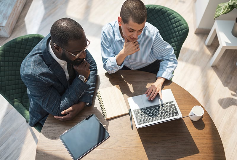 Two business professionals collaborating using technology in a bright office environment.