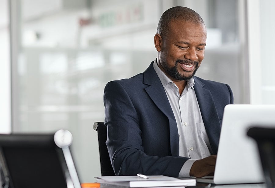 business man smiling down at laptop