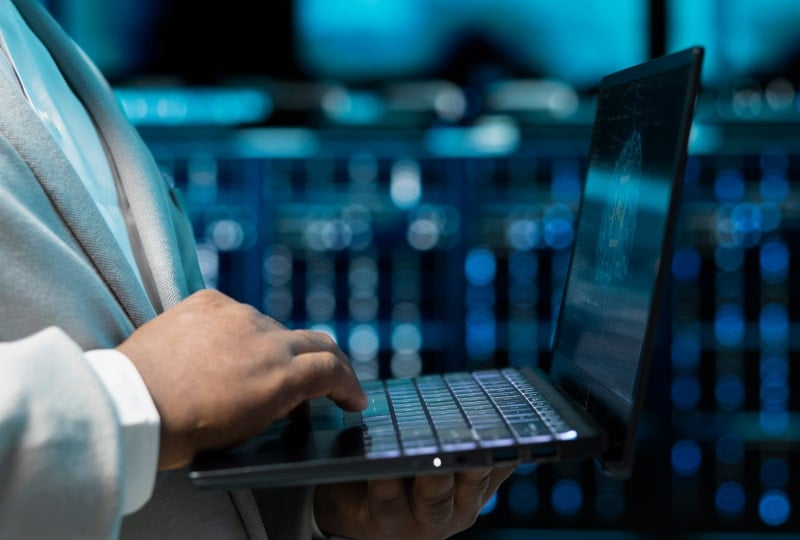 一名男子正在笔记本电脑上输入