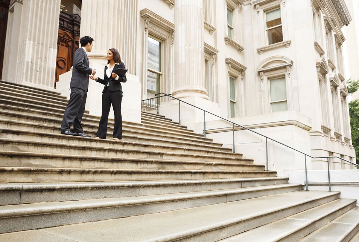 two people in suits discussing on a stair case