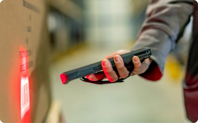某人拿着移动 scanning device 的手部特写。