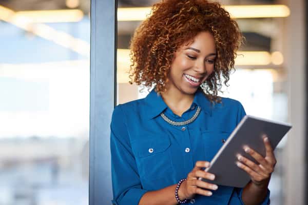 woman smiling down at ipad