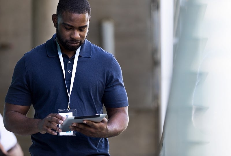 strong man standing next to a marble pillar holding a mobile device