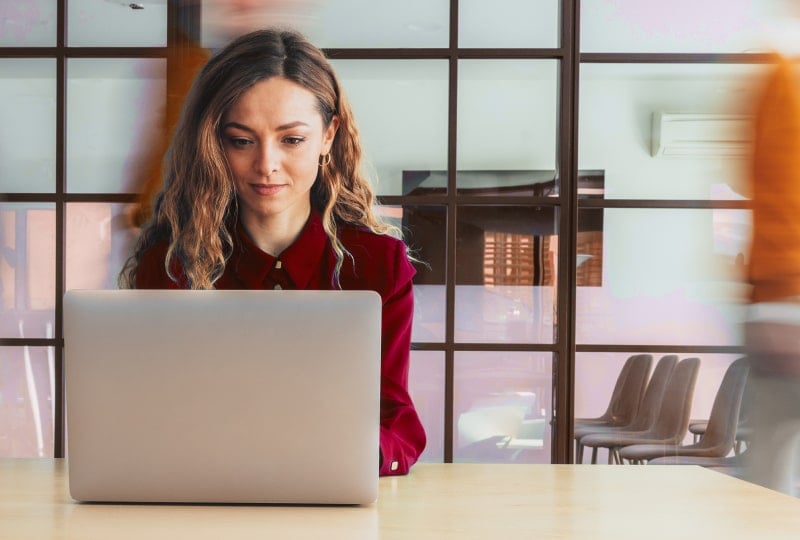 a woman is using a laptop computer in an office
