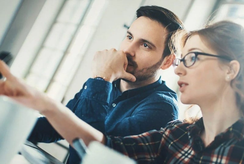 Une femme et un homme discutent des données dans un bureau.