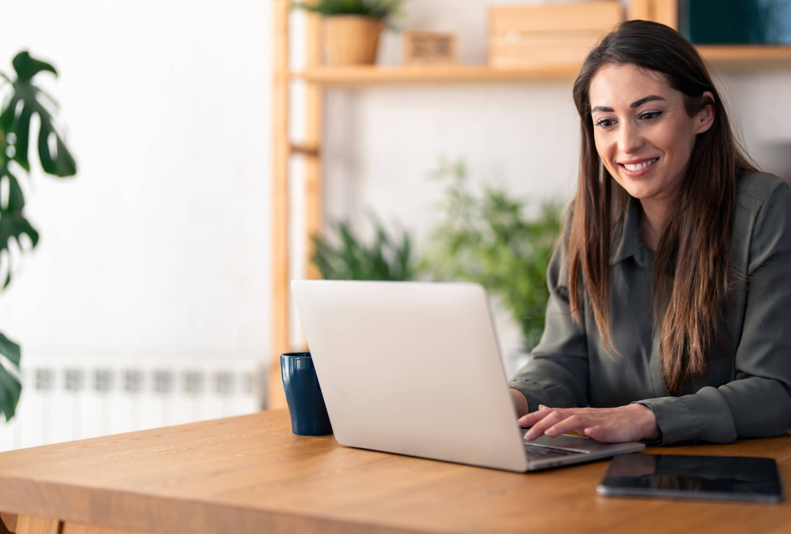 Smiling woman interacting with a laptop.