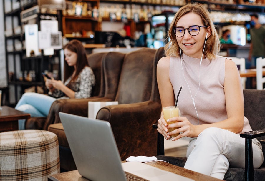 woman working remotely in coffee shop